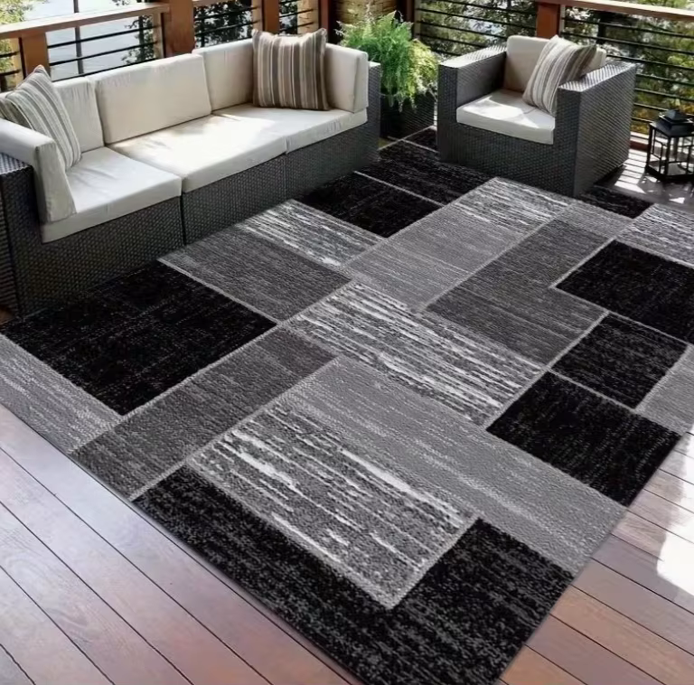 Ceci est un grand tapis avec une base noire, orné d'une texture ovale géométrique rose, fabriqué ave